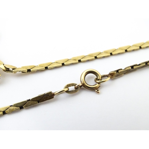 644 - A 9ct gold necklace with textured oval detail to lower section. Bearing import marks for London 1972... 