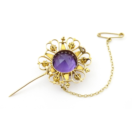 660 - A  Victorian yellow metal brooch of stylised star form set with amethyst seed pearl detail. Together... 