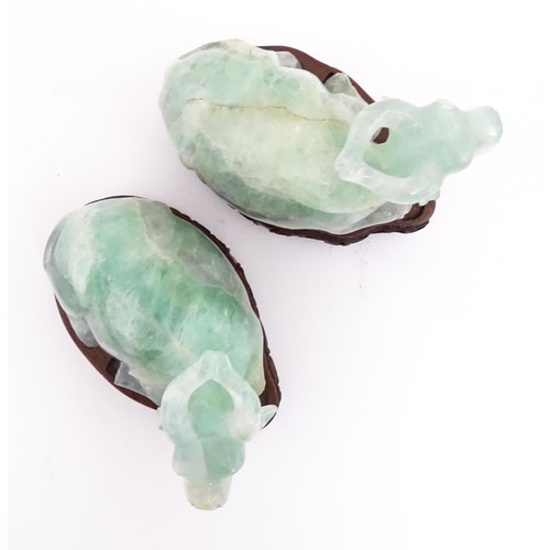 1017 - Two Chinese carved green fluorite models of recumbent buffalo, on wooden stands. Approx. 5