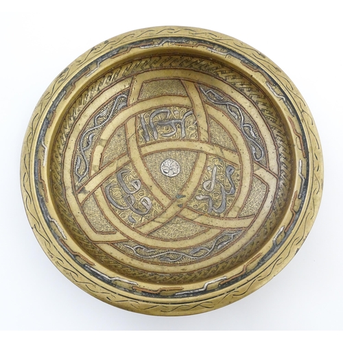 1037 - A Middle Eastern brass dish / bowl with incised detail and inlaid white metal and copper decoration ... 