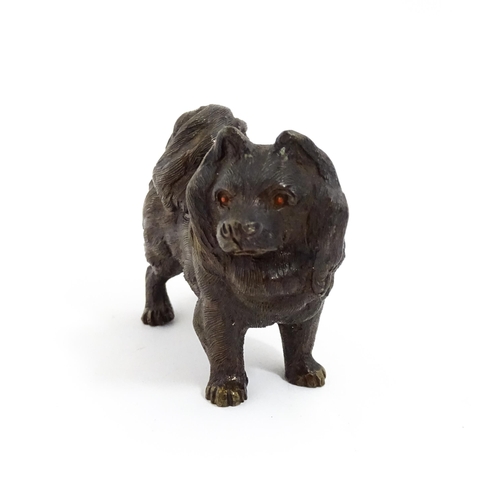 1051 - A 20thC cast bronze model of a dog with red painted eyes. Approx. 2 1/4