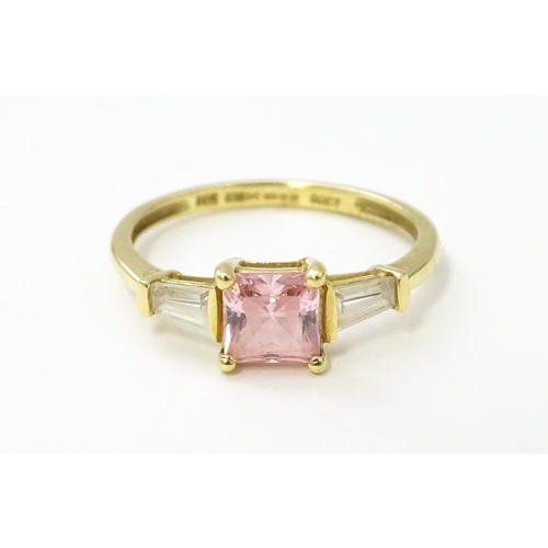 531 - A 14ct gold ring set with central pink stone, flanked by white stones. Ring size approx. S 1/2