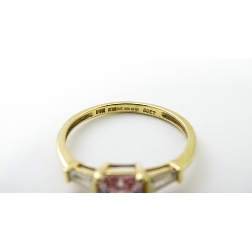 531 - A 14ct gold ring set with central pink stone, flanked by white stones. Ring size approx. S 1/2