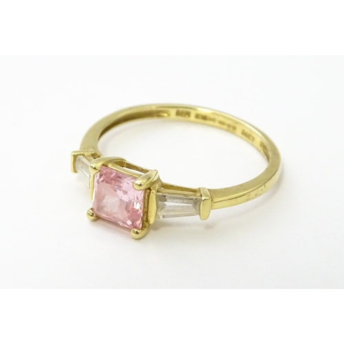 531 - A 14ct gold ring set with central pink stone, flanked by white stones. Ring size approx. S 1/2