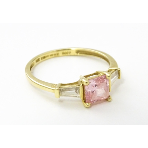 531 - A 14ct gold ring set with central pink stone, flanked by white stones. Ring size approx. S 1/2