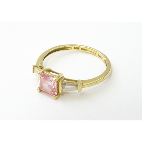 531 - A 14ct gold ring set with central pink stone, flanked by white stones. Ring size approx. S 1/2