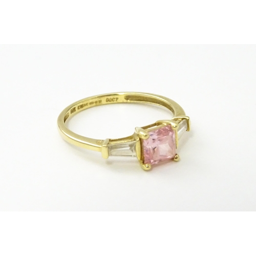 531 - A 14ct gold ring set with central pink stone, flanked by white stones. Ring size approx. S 1/2