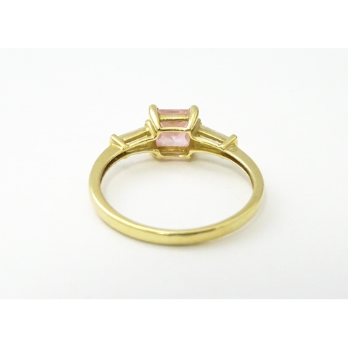 531 - A 14ct gold ring set with central pink stone, flanked by white stones. Ring size approx. S 1/2