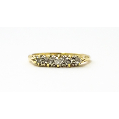 532 - A gold ring set with five graduated diamonds. Ring size approx. L 1/2