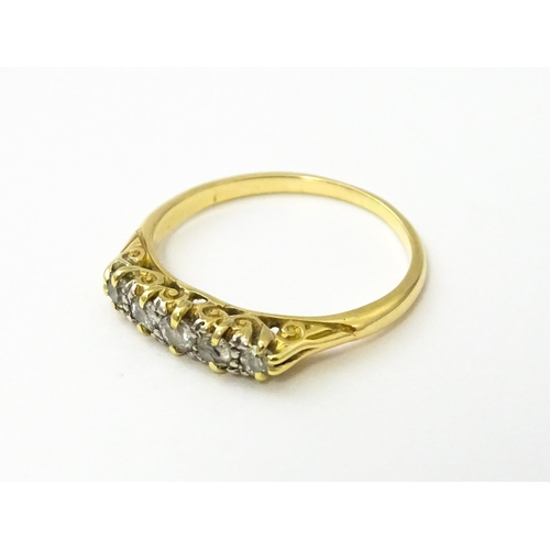 532 - A gold ring set with five graduated diamonds. Ring size approx. L 1/2