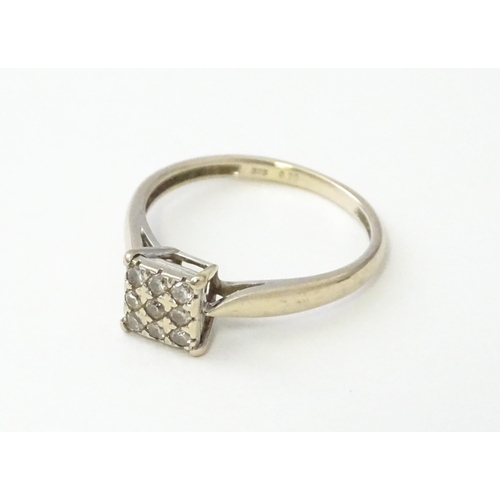 543 - A 9ct white gold ring set with nine diamonds in a square setting. Ring size approx. M 1/2