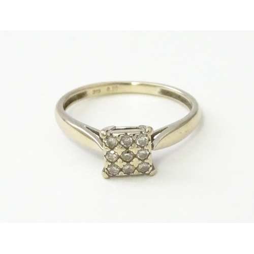 543 - A 9ct white gold ring set with nine diamonds in a square setting. Ring size approx. M 1/2