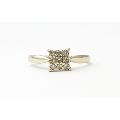 543 - A 9ct white gold ring set with nine diamonds in a square setting. Ring size approx. M 1/2