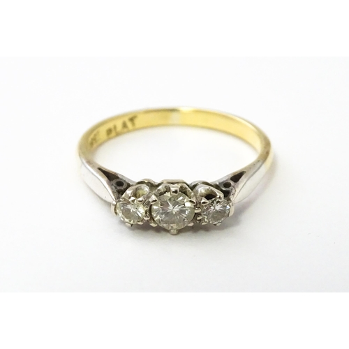 544 - An 18ct gold ring with platinum set trio of diamonds. Ring size approx. L 1/2