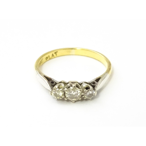 544 - An 18ct gold ring with platinum set trio of diamonds. Ring size approx. L 1/2