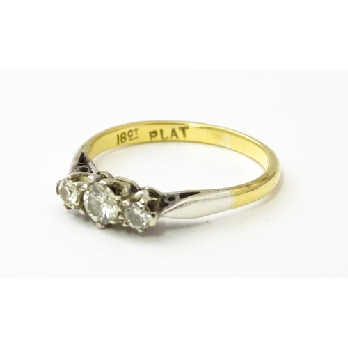 544 - An 18ct gold ring with platinum set trio of diamonds. Ring size approx. L 1/2