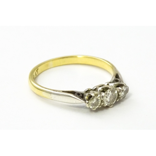 544 - An 18ct gold ring with platinum set trio of diamonds. Ring size approx. L 1/2