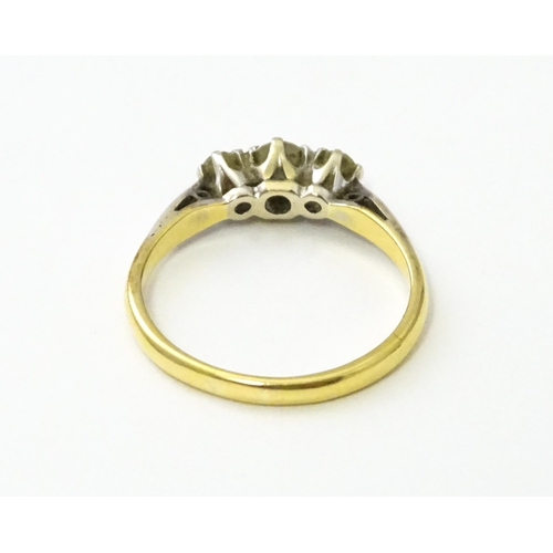 544 - An 18ct gold ring with platinum set trio of diamonds. Ring size approx. L 1/2