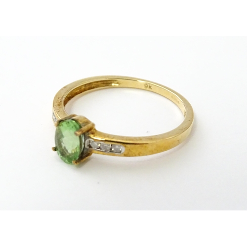 547 - A 9ct gold ring set with central Paraiba tourmaline flanked by diamonds. Ring size approx. N.