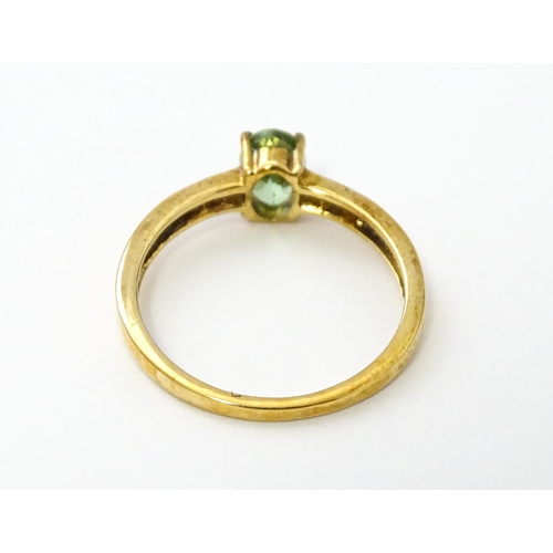 547 - A 9ct gold ring set with central Paraiba tourmaline flanked by diamonds. Ring size approx. N.