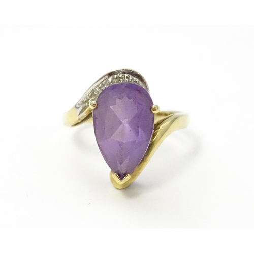 549 - A 9ct gold ring set with central amethyst and diamond. Ring size approx. O 1/2