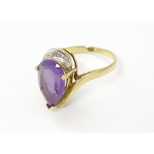 549 - A 9ct gold ring set with central amethyst and diamond. Ring size approx. O 1/2