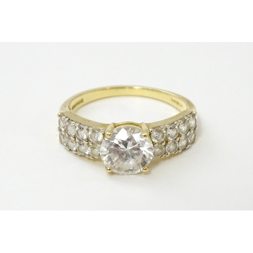 554 - A 14ct gold ring set with central white stone flanked by further white stones. Ring size approx. R 1... 