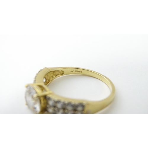 554 - A 14ct gold ring set with central white stone flanked by further white stones. Ring size approx. R 1... 