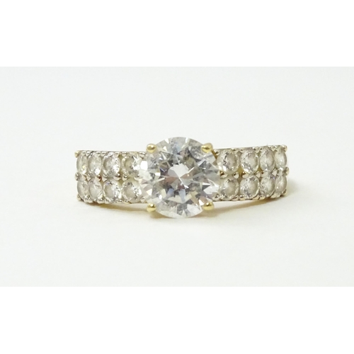 554 - A 14ct gold ring set with central white stone flanked by further white stones. Ring size approx. R 1... 