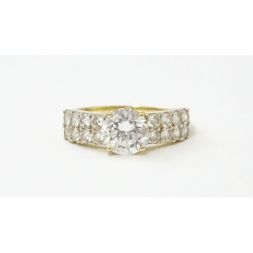 554 - A 14ct gold ring set with central white stone flanked by further white stones. Ring size approx. R 1... 