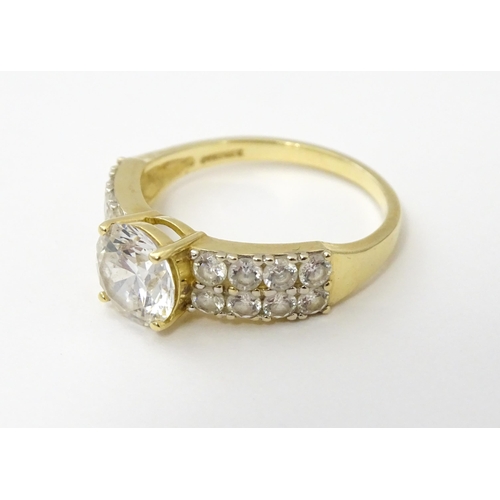 554 - A 14ct gold ring set with central white stone flanked by further white stones. Ring size approx. R 1... 