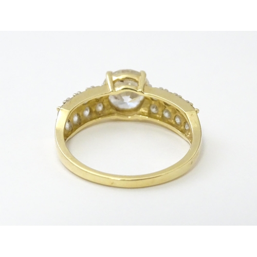 554 - A 14ct gold ring set with central white stone flanked by further white stones. Ring size approx. R 1... 