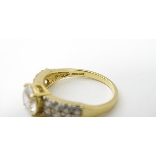 554 - A 14ct gold ring set with central white stone flanked by further white stones. Ring size approx. R 1... 