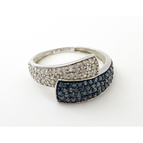 556 - A 9ct white gold ring set with blue and white diamonds. Ring size approx. N