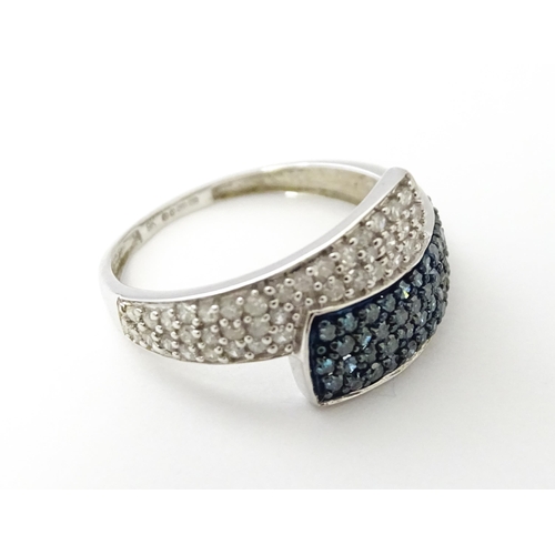 556 - A 9ct white gold ring set with blue and white diamonds. Ring size approx. N