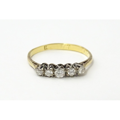 557 - An 18ct gold ring set with five diamonds in a linear setting. Ring size approx. N 1/2