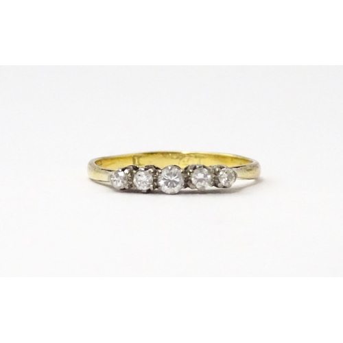 557 - An 18ct gold ring set with five diamonds in a linear setting. Ring size approx. N 1/2