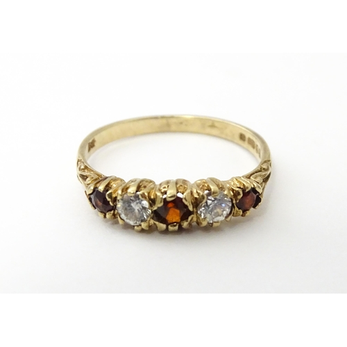 558 - A 9ct gold ring set with red and white stones in a linear setting. Ring size approx. M