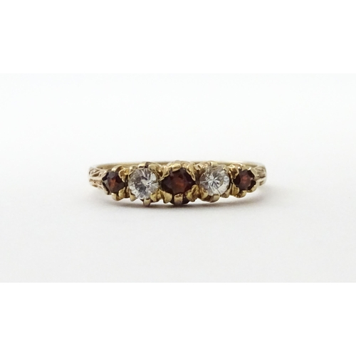 558 - A 9ct gold ring set with red and white stones in a linear setting. Ring size approx. M