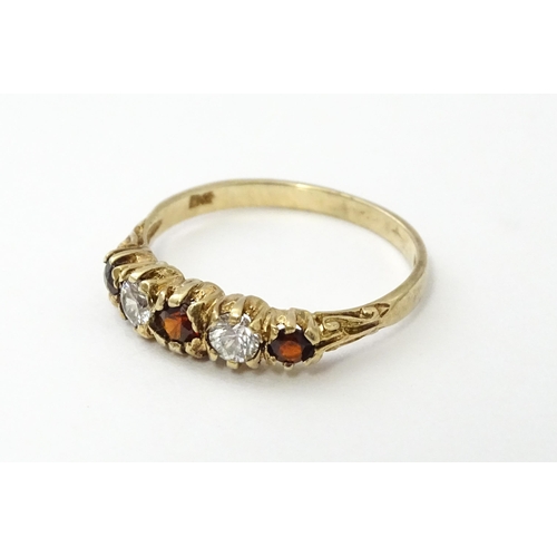 558 - A 9ct gold ring set with red and white stones in a linear setting. Ring size approx. M