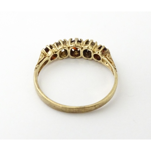 558 - A 9ct gold ring set with red and white stones in a linear setting. Ring size approx. M