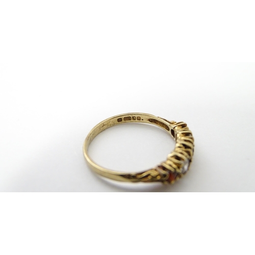 558 - A 9ct gold ring set with red and white stones in a linear setting. Ring size approx. M