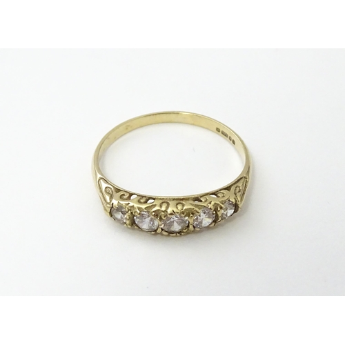 560 - A 9ct gold ring set with five white stones in a linear setting. Ring size approx. O 1/2