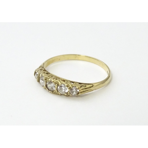 560 - A 9ct gold ring set with five white stones in a linear setting. Ring size approx. O 1/2