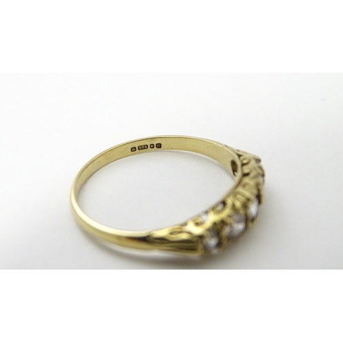 560 - A 9ct gold ring set with five white stones in a linear setting. Ring size approx. O 1/2