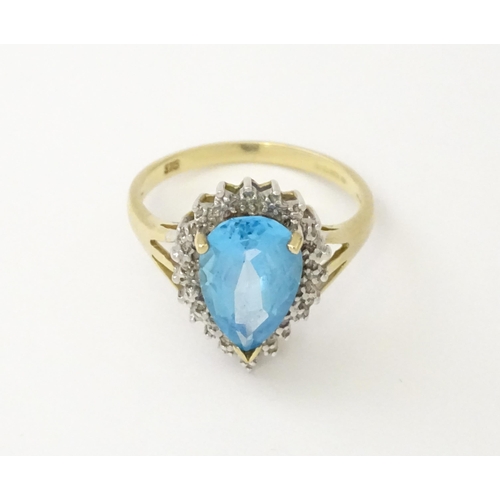 562 - A 9ct gold cocktail ring set with central topaz and diamond. Ring size approx. P