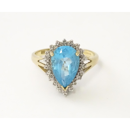 562 - A 9ct gold cocktail ring set with central topaz and diamond. Ring size approx. P