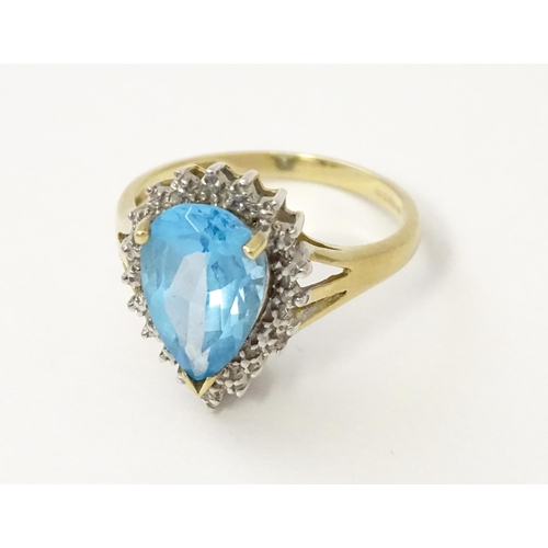 562 - A 9ct gold cocktail ring set with central topaz and diamond. Ring size approx. P