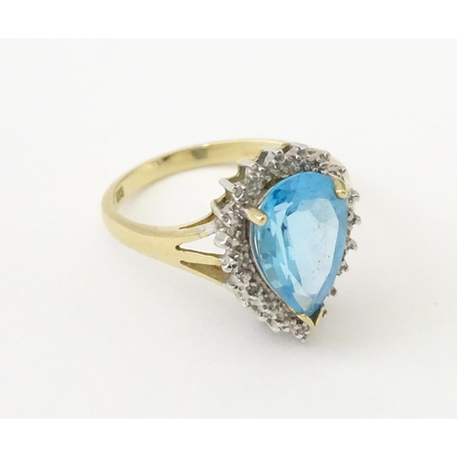 562 - A 9ct gold cocktail ring set with central topaz and diamond. Ring size approx. P