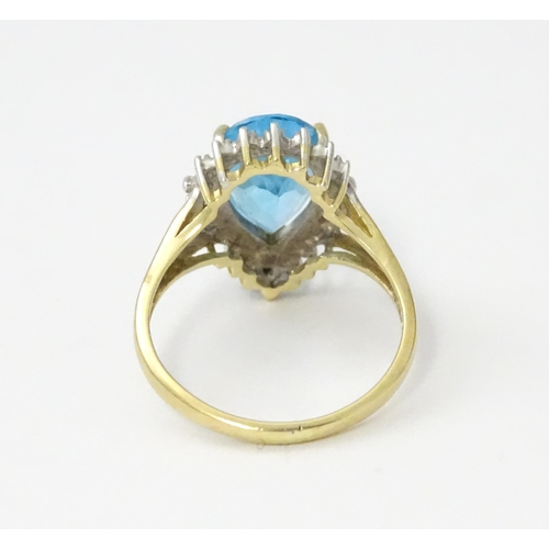 562 - A 9ct gold cocktail ring set with central topaz and diamond. Ring size approx. P